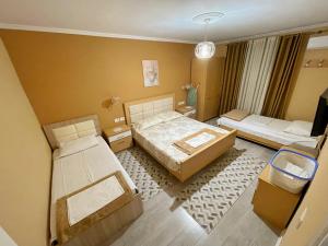 Habitación pequeña con 2 camas y sofá en Elite Apartments Korçë, en Korçë