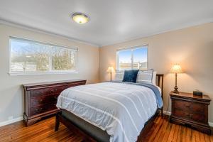 ein Schlafzimmer mit einem Bett und zwei Fenstern in der Unterkunft Whidbey Sunrise Formerly Canterbury Sunrise in Oak Harbor