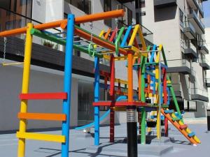 un colorato parco giochi con scivolo di fronte a un edificio di SuiteGreen, exclusivo apartaestudio !! a Ibagué