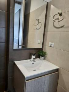 uma casa de banho com um lavatório e um espelho em SuiteGreen, exclusivo apartaestudio !! em Ibagué