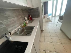 a kitchen with a sink and a tile floor at Cond. St. Tropez in San Juan