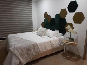 a bedroom with a large bed and a side table at SuiteGreen, exclusivo apartaestudio !! in Ibagué