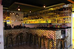 a bar with bar stools and bottles of alcohol at Hotel Boutique M&F in Tequisquiapan