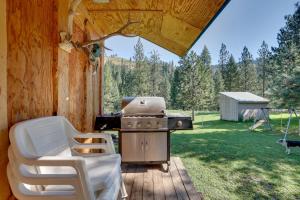 einen Grill und Stühle auf einer Terrasse in einer Hütte in der Unterkunft Cozy Countryside Cabin in Robie Creek Park! in Boise