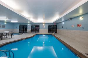 Holiday Inn Express Rochester South - Mayo Area, an IHG Hotel في روتشستر: حمام سباحة بمياه زرقاء في غرفة في الفندق