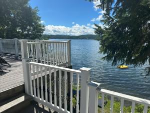 une terrasse en bois avec vue sur le lac dans l'établissement Claddagh Cottage, à Richfield Springs