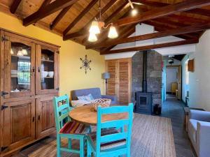 uma sala de estar com uma mesa de madeira e cadeiras em Casa do Laureano em Santo Amaro