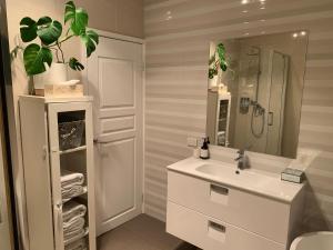 a white bathroom with a sink and a shower at Koombana Escape in Perth