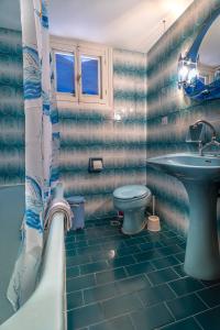 a bathroom with a sink and a toilet and a tub at La Skala Eressos Holiday Apartments in Skala Eresou