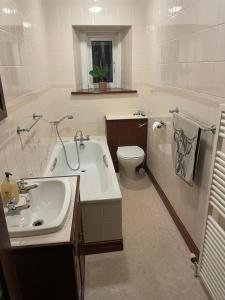 a white bathroom with a sink and a toilet at The Old Manse B&B in Thurso