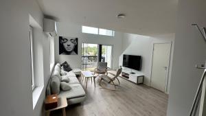 a living room with a couch and a tv at Top Floor Apartment Årossanden 5 A in Kristiansand