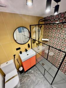 uma casa de banho com um lavatório, um espelho e um WC. em Elegante Apartamento TRES COLORES em Alicante