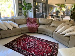 un soggiorno con divano e tappeto rosso di Koombana Escape a Perth