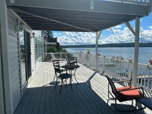 a porch with chairs and a table and a view of the water at Chateau du Lac in Richfield Springs