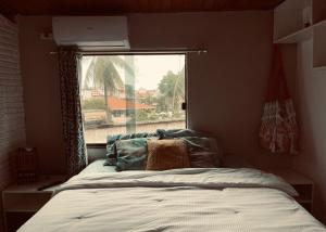 um quarto com uma cama em frente a uma janela em Studio 1 casazul em Salvador