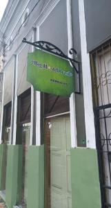 una señal verde colgando fuera de un edificio en Big Hostel Brasil, en Manaus