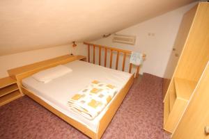 ein kleines Schlafzimmer mit einem Bett mit weißer Bettwäsche in der Unterkunft Apartments by the sea Unesic - Unije, Losinj - 8044 in Unije