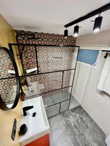ein Bad mit einem Waschbecken und einem Spiegel in der Unterkunft Elegante Apartamento TRES COLORES in Alicante