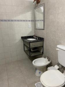 ein Badezimmer mit einem weißen WC und einem Waschbecken in der Unterkunft Glamping Urbano Posadas in Posadas
