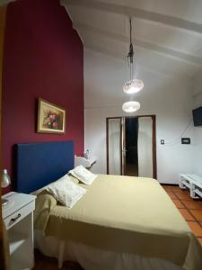 Schlafzimmer mit einem großen Bett mit blauem Kopfteil in der Unterkunft Glamping Urbano Posadas in Posadas