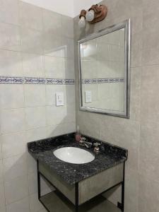 ein Bad mit einem Waschbecken und einem Spiegel in der Unterkunft Glamping Urbano Posadas in Posadas