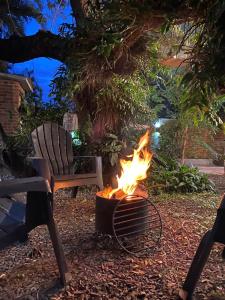 a fire pit next to a chair and a bench at Glamping Urbano Posadas in Posadas