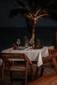 a table with two chairs and a table with wine glasses at Punta Blanca Beach House in Costa Mujeres
