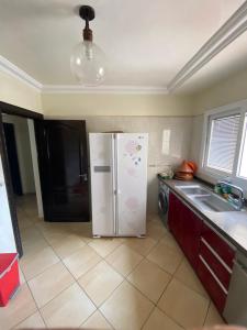 Una cocina con un refrigerador blanco y un fregadero. en Appart centre ville, en Agadir 2 fotos más