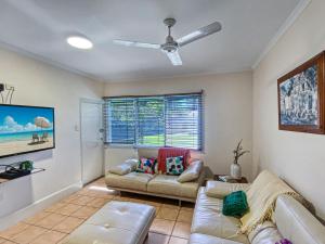 a living room with two couches and a ceiling fan at Picnic Bay Apartments Unit 1 in Picnic Bay