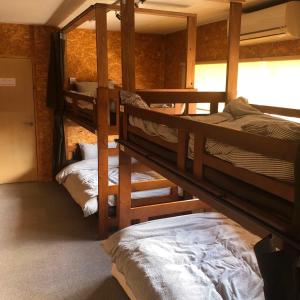 a room with three bunk beds in a house at GUEST HOUSE NAGORIYA in Hikone