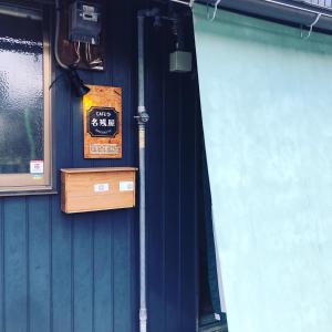 ein blaues Gebäude mit einem Schild an der Tür in der Unterkunft GUEST HOUSE NAGORIYA in Hikone