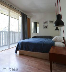 una camera con un letto blu e una grande finestra di Two bedroom apartment in the heart of La Roma a Città del Messico