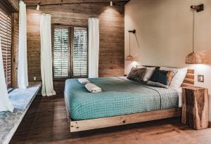 sypialnia z łóżkiem i drewnianymi ścianami w obiekcie Bocas Garden Lodges w mieście Bocas del Toro