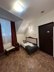 um pequeno quarto com uma cama e uma janela em Pałac Tarnowskich Hotel & Restauracja & SPA em Ostrowiec Świetokrzyski