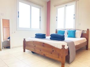 a bedroom with a bed with blue pillows on it at Sunset Pearl Holiday Villa in Ayia Napa