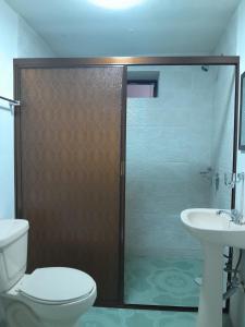 uma casa de banho com um chuveiro, um WC e um lavatório. em Hotel Posada Doña Maria Esther em Zacatlán