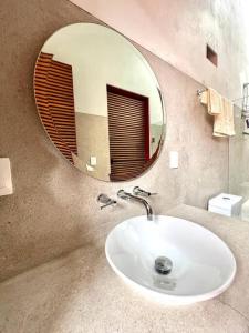 een badkamer met een witte wastafel en een spiegel bij Casa Jacarandas in Chapala