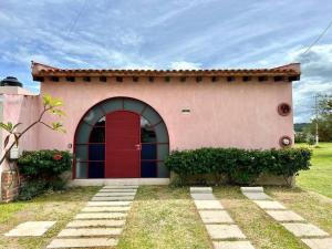 una casa con una puerta roja en un patio en Casa Jacarandas, en Chapala