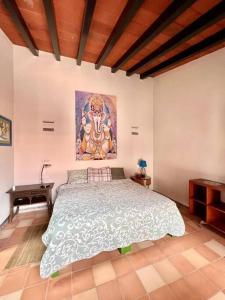 1 dormitorio con 1 cama grande y una pintura en la pared en Casa Jacarandas, en Chapala