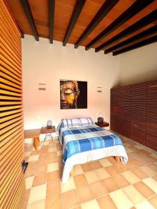 een slaapkamer met een bed en een schilderij aan de muur bij Casa Jacarandas in Chapala