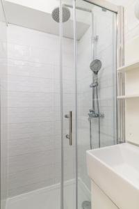 um chuveiro com uma porta de vidro ao lado de um lavatório branco em Apartments with WiFi Pula - 21407 em Pula