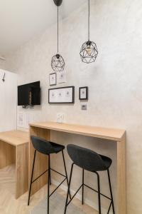 uma cozinha com um bar de madeira com 2 cadeiras em Apartments with WiFi Pula - 21407 em Pula