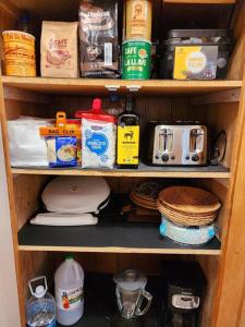 una estantería de madera con comida y otros artículos. en The Ponderosa en Running Springs