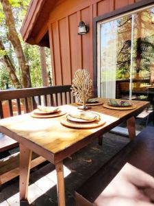 una mesa de madera en un porche con una mesa en The Ponderosa en Running Springs