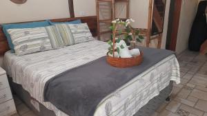 ein Bett mit einem Korb mit Handtüchern und Blumen darauf in der Unterkunft Chalés Bonito Paraty in Paraty