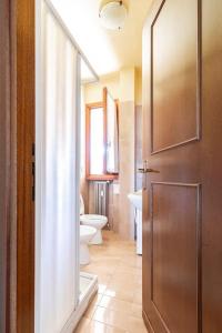 ein Bad mit einer Tür, einem WC und einem Waschbecken in der Unterkunft Arona Vista Panoramica in Dagnente