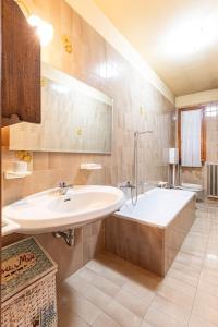 ein Badezimmer mit einem Waschbecken und einer Badewanne in der Unterkunft Arona Vista Panoramica in Dagnente