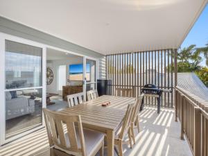 a wooden table and chairs on a balcony at Beach City 3 Bedroom Modern Townhouse in Maroochydore