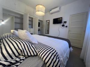 sypialnia z 2 łóżkami i poduszkami w paski w obiekcie Quiet, Central Apartment To Feel Good - www_el-rincon_rentals w mieście La Rioja
