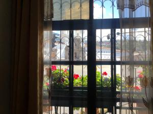 a window with a view of a flower garden at Hostal Benalcazar in Quito